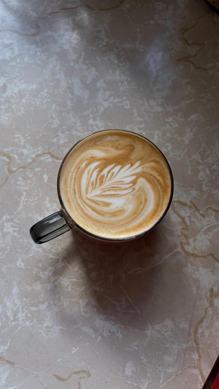 Taza de latte con arte de hoja sobre mármol